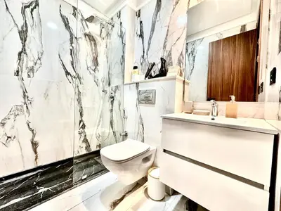 a white bathroom with a toilet and a sink at Cozy & Central with Terrace, Parking and Fiber Wifi in Casablanca