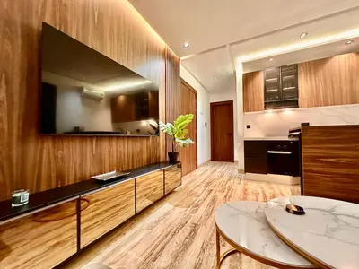 a living room with a large tv and a table at Cozy & Central with Terrace, Parking and Fiber Wifi in Casablanca