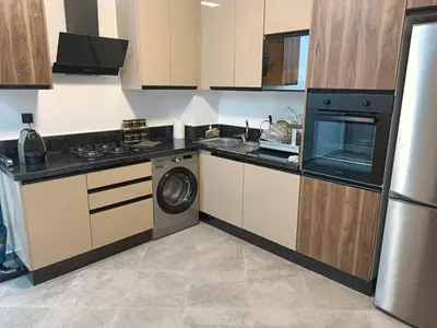 a kitchen with a stove and a washer and dryer at Appartement haut standing piscine et fitness in Mohammedia