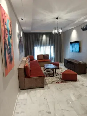 a living room with a couch and a table at Appartement haut standing piscine et fitness in Mohammedia