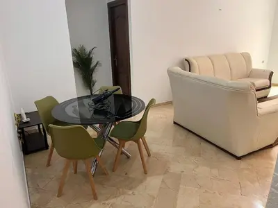 a living room with a glass table and chairs at 2 bedroom apartment with breakfast included in Casablanca