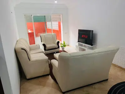 a living room with two chairs and a tv at 2 bedroom apartment with breakfast included in Casablanca
