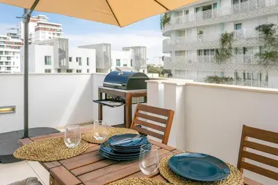a table on a balcony with an umbrella at CFC, cozy 2 bedrooms apartment living room in Casablanca