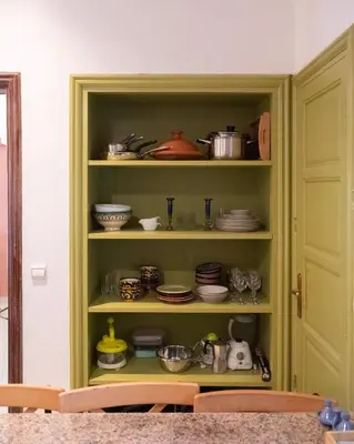 a green cabinet filled with dishes and pots and pans at Downtown Casablanca Living Terrace & Tram Access in Casablanca