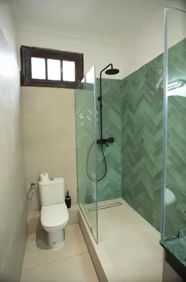 a bathroom with a toilet and a glass shower at Downtown Casablanca Living Terrace & Tram Access in Casablanca