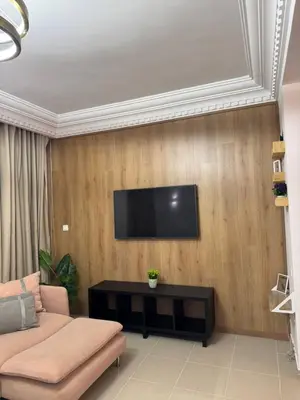 a living room with a couch and a tv on a wall at Face à la Gare et au Tramway Moderne, Calme avec Resto sur place possible in Casablanca