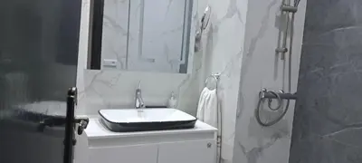 a white bathroom with a sink and a shower at Appartement près de la corniche in Casablanca