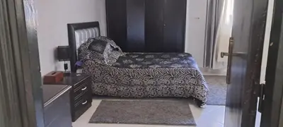 a bedroom with a couch and a dresser and a bed at Appartement près de la corniche in Casablanca