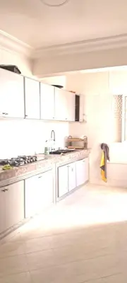 a kitchen with white cabinets and a sink at Appartement près de la corniche in Casablanca