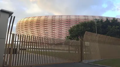 a building with a wooden fence in front of it at Hébergement de lux près stades in Rabat