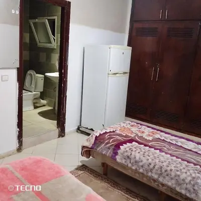 a kitchen with a refrigerator and a bed in a room at Hébergement de lux près stades in Rabat