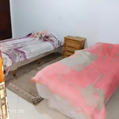 a bedroom with a bed and a dresser and a pink blanket at Hébergement de lux près stades in Rabat