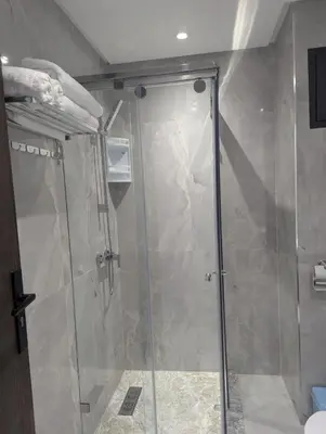 a shower with a glass door in a bathroom at Studio cosy avec patio privé -centre Rabat- Océan in Rabat