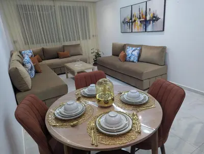 a living room with a table and a couch at Studio cosy avec patio privé -centre Rabat- Océan in Rabat
