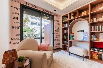 a living room with a chair and bookshelves at Uptown Casa Anfa Luxury at Casa Finance City in Casablanca