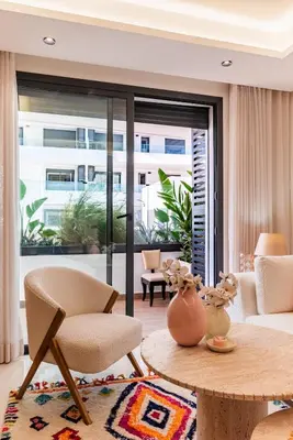a living room with a table and chairs and a large window at Uptown Casa Anfa Luxury at Casa Finance City in Casablanca