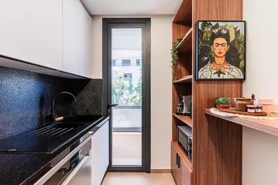 a kitchen with black countertops and wooden cabinets at Uptown Casa Anfa Luxury at Casa Finance City in Casablanca
