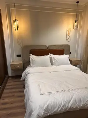a bedroom with a large white bed with two night stands at Studio Zen in Maarif