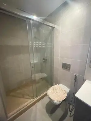 a bathroom with a glass shower with a toilet at appartement 5min a pied du stade in Rabat