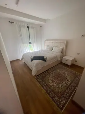 a bedroom with a bed with a rug and a window at appartement 5min a pied du stade in Rabat