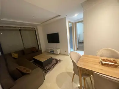 a living room with a couch and a table at appartement 5min a pied du stade in Rabat