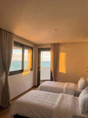 two beds in a hotel room with a view of the ocean at Epic Oceanfront Flat - 360 Sea View in Casablanca