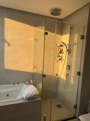 a bathroom with a shower and a tub and a sink at Epic Oceanfront Flat - 360 Sea View in Casablanca