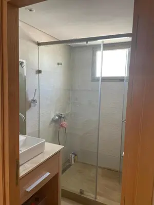 a bathroom with a glass shower and a sink at Beautiful beachfront villa in Dar Bouazza