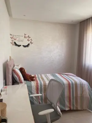 a childs bedroom with a bed and a chair at Beautiful beachfront villa in Dar Bouazza
