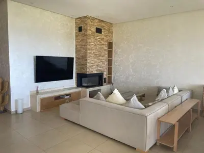 a living room with a couch and a flat screen tv at Beautiful beachfront villa in Dar Bouazza