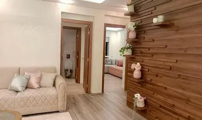 a living room with a couch and a wooden wall at Luxury SeaView Apartment 2 Minutes From Beachfront in Rabat