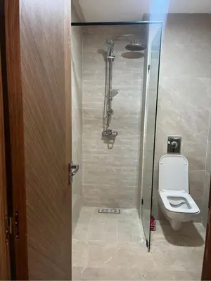 a bathroom with a toilet and a glass shower door at residence cheickno firdaous casablanca in Settat