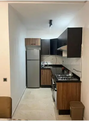 a kitchen with a stove and a refrigerator at residence cheickno firdaous casablanca in Settat