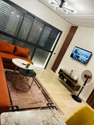 a living room with a couch and a table and a tv at residence cheickno firdaous casablanca in Settat
