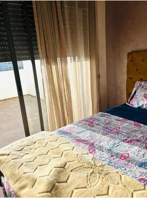a bed in a bedroom with a window at residence cheickno firdaous casablanca in Settat