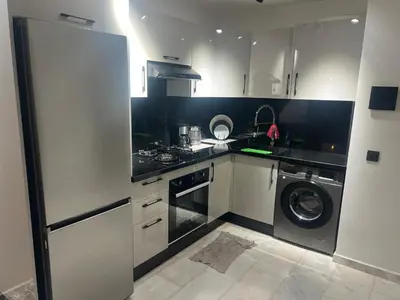 a kitchen with white cabinets and a washer and dryer at Casablanca Luxe studio in Casablanca