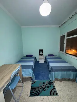 a room with two beds and a window at House for rent in Agdal in Rabat