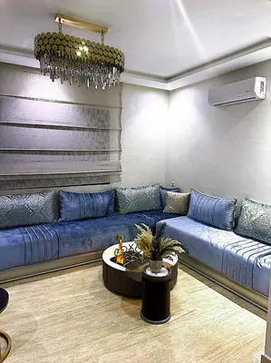 a living room with a blue couch and a table at Host By Med in Casablanca