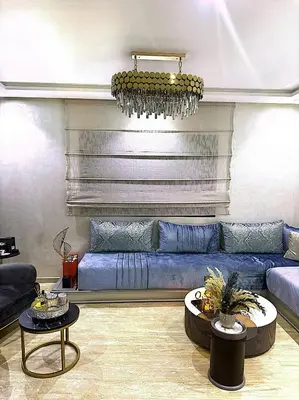 a living room with a blue couch and two tables at Host By Med in Casablanca