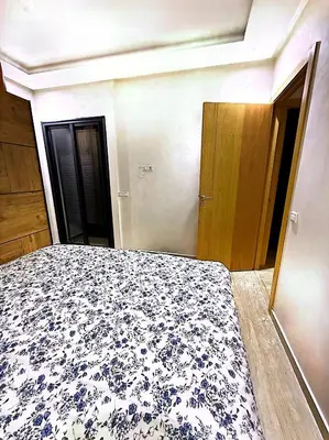 a bedroom with a bed with a blue and white blanket at Host By Med in Casablanca