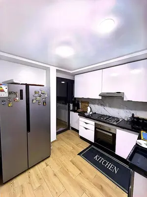 a kitchen with a stainless steel refrigerator and wooden floors at Host By Med in Casablanca