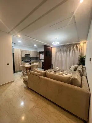 a living room with a large couch and a kitchen at Modern fully-equipped apartment in a residence in Pont Blondin