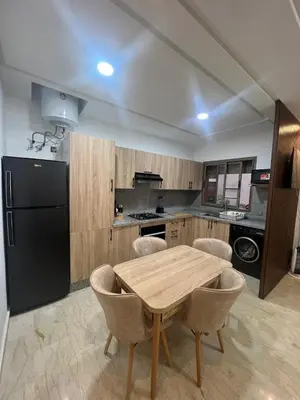 a kitchen with a wooden table and a black refrigerator at Modern fully-equipped apartment in a residence in Pont Blondin