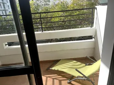 a yellow chair on a balcony with a window at Beautiful 3 Bedroom in Heart of Hay Riad in Rabat