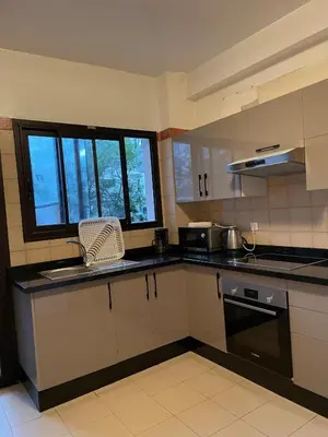 a kitchen with white cabinets and a sink and a window at Beautiful 3 Bedroom in Heart of Hay Riad in Rabat