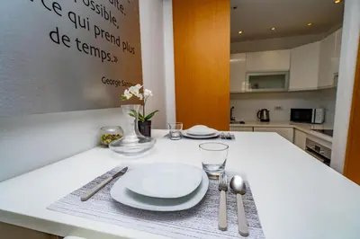 a kitchen with a table with plates and silverware at Appartement cosy & chic Triangle d'or in Casablanca