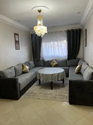 a living room with a couch and a chandelier at Appartement in Mohammedia