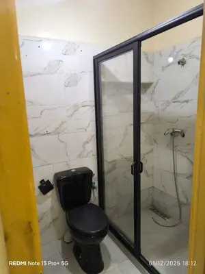 a bathroom with a toilet and a glass shower at Appartement in Mohammedia