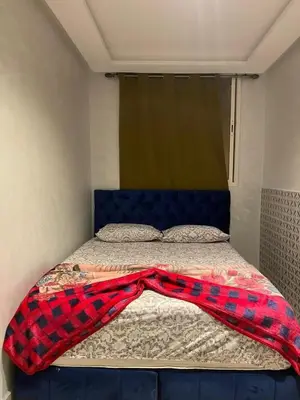 a bed with a plaid blanket on top of it at pretty apparently in Casablanca