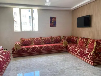 a living room with red couches and a flat screen tv at pretty apparently in Casablanca